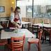 Ayse's Turkish Cafe employee Kelly Harbron clears a table in the dining room on Wednesday. Melanie Maxwell I AnnArbor.com